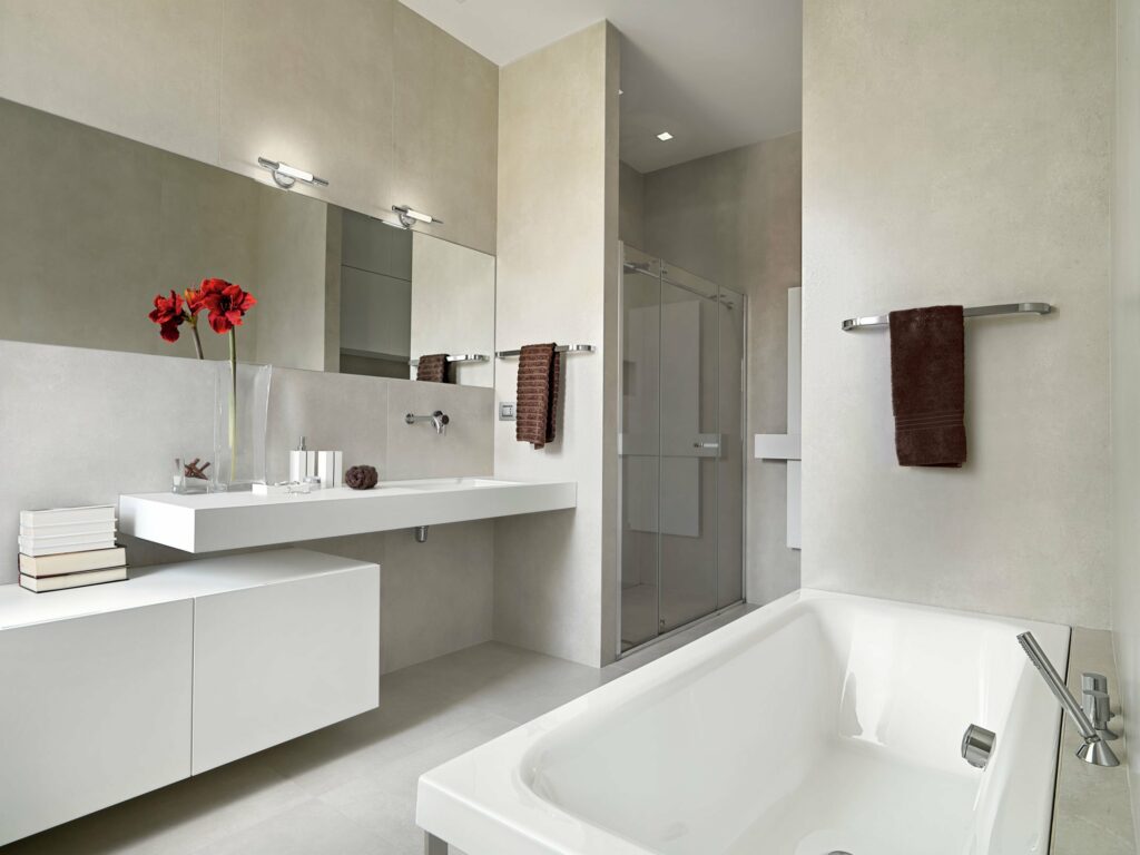 A bathroom with white walls and red towels.